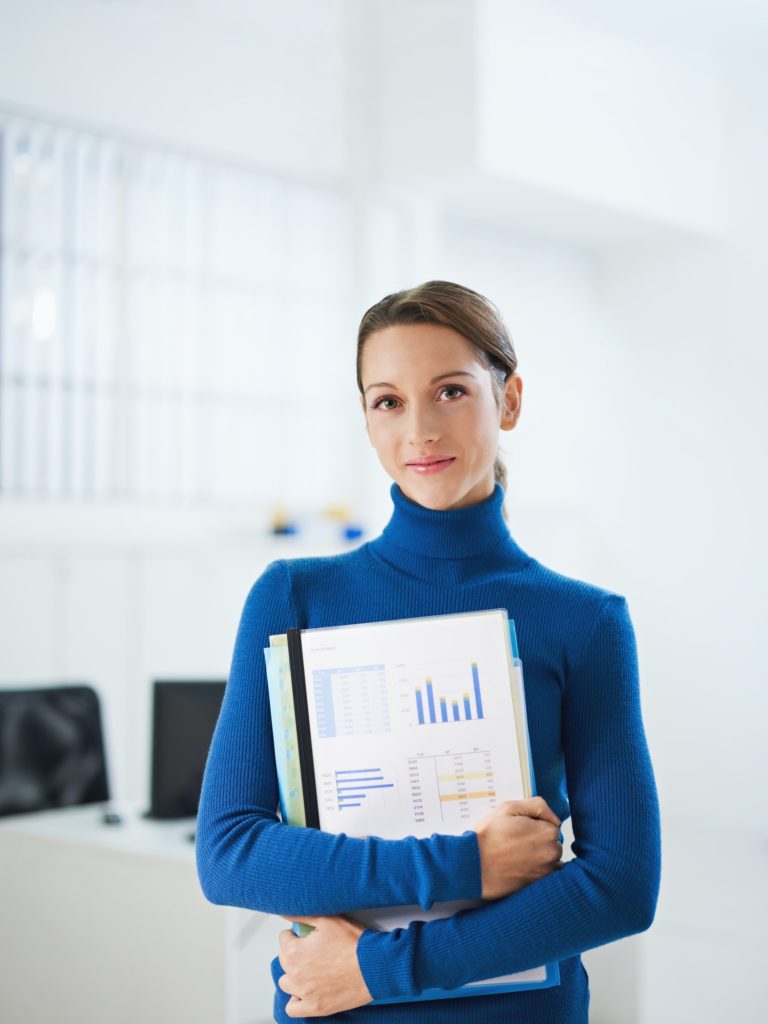 Young Female Secretary Looking At Camera Holding Folder